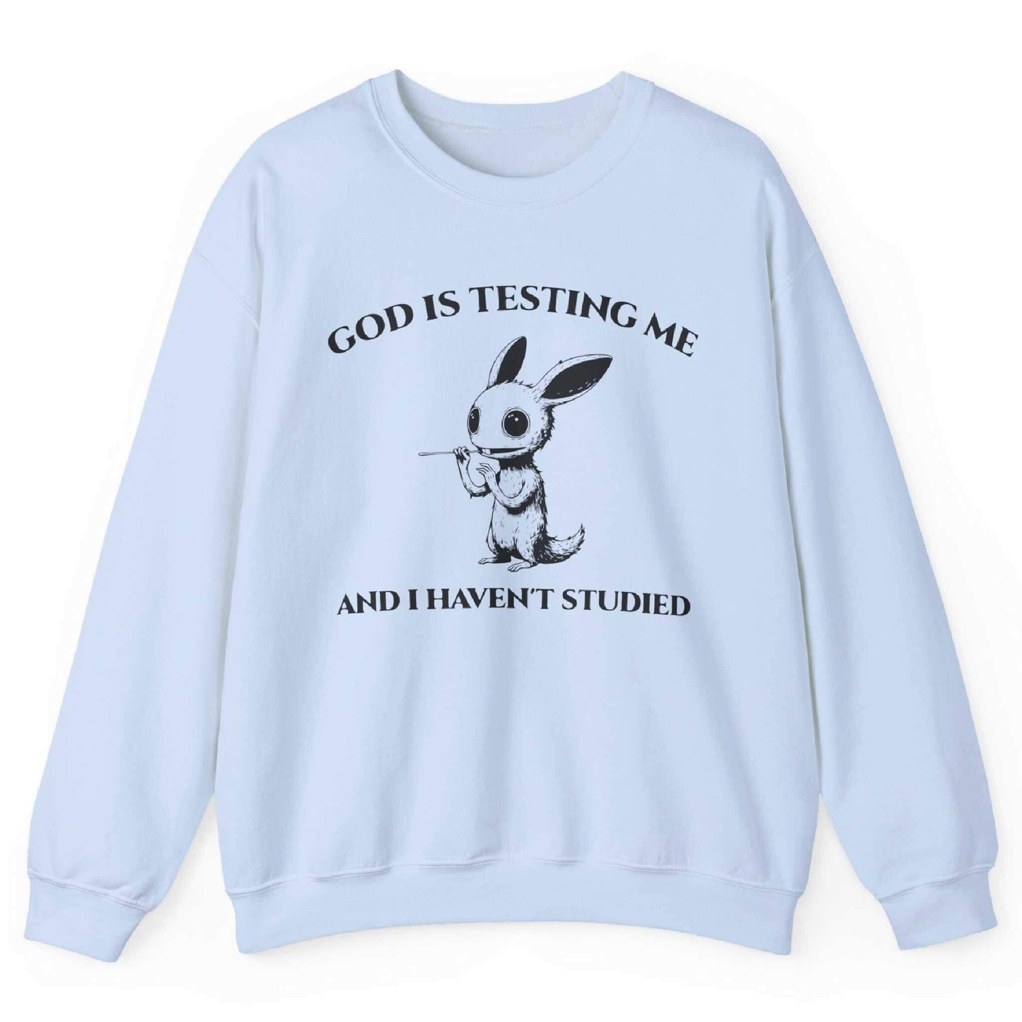 Light Blue sweatshirt with quirky creature graphic and “God Is Testing Me And I Haven’t Studied” text – front view, by Shirtcasm