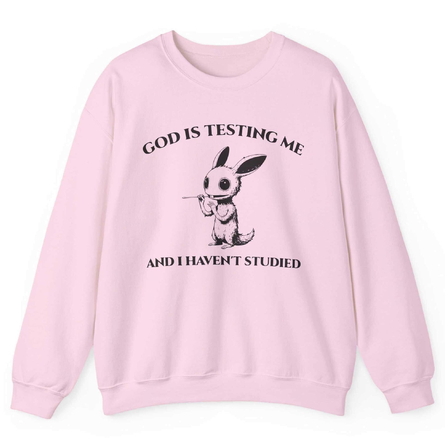 Light pink sweatshirt with quirky creature graphic and “God Is Testing Me And I Haven’t Studied” text – front view, by Shirtcasm