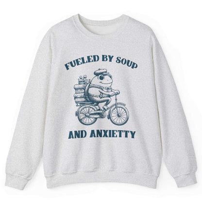 Ash sweatshirt with frog riding bicycle carrying soup cans and “Fueled by Soup and Anxiety” text – front view, by Shirtcasm